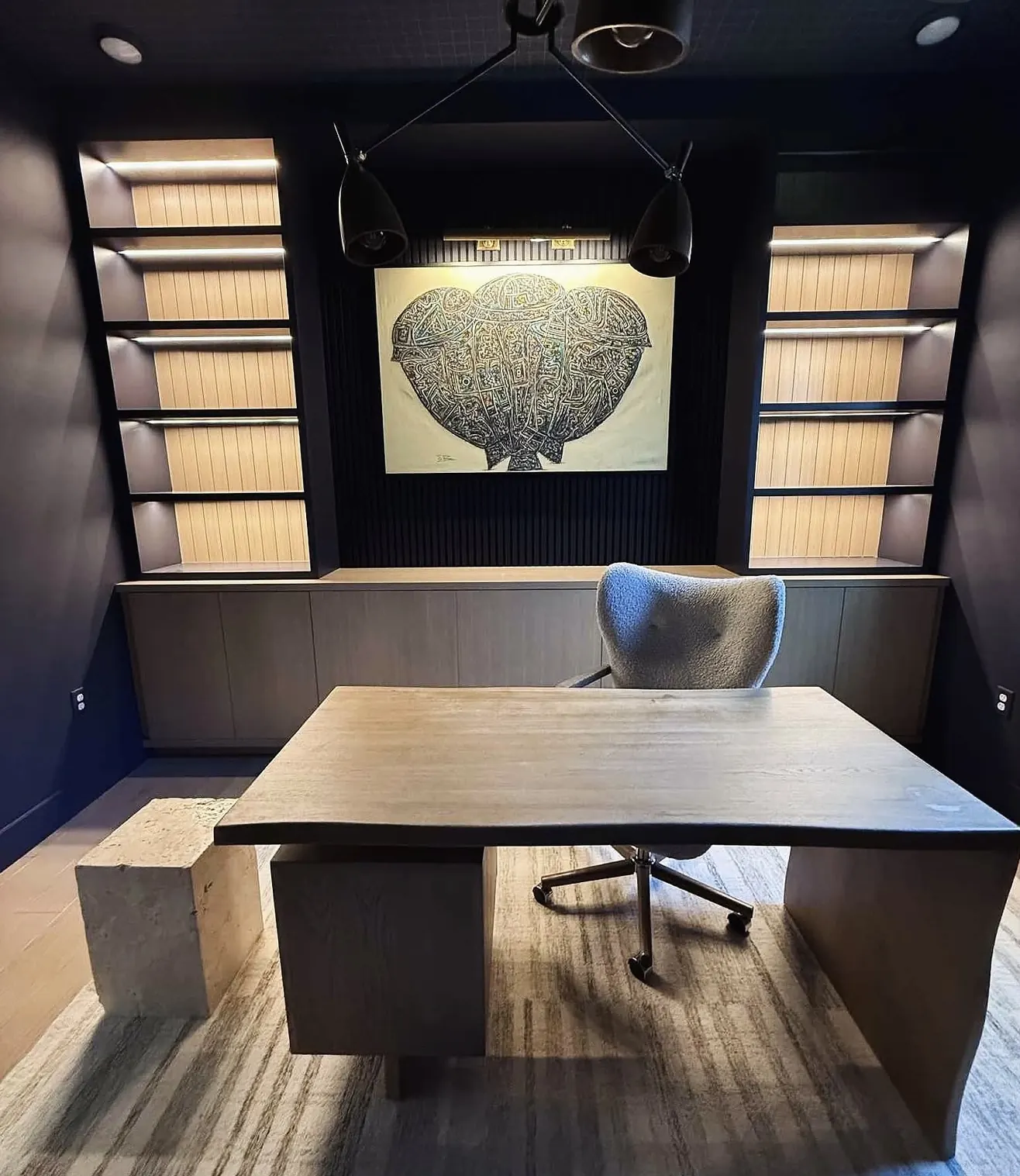 Custom home office with lit shelving by CWL Construction